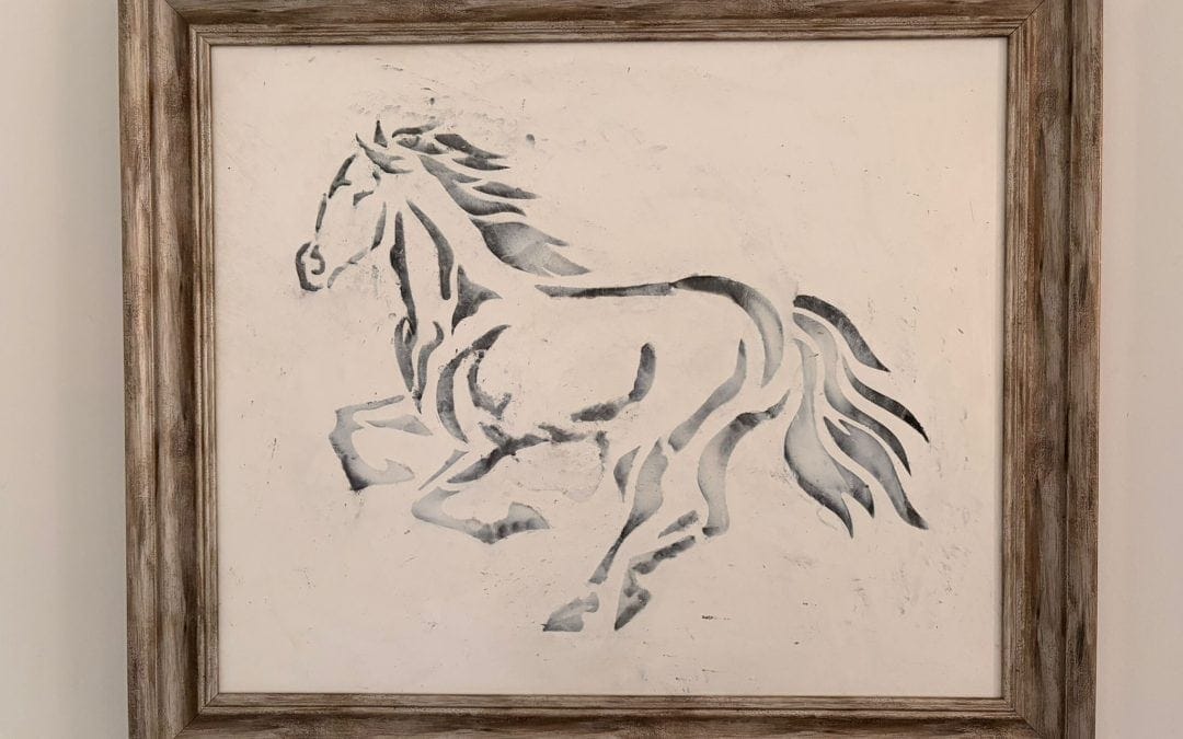 Rustic framed painting of a running horse in neutral tones.