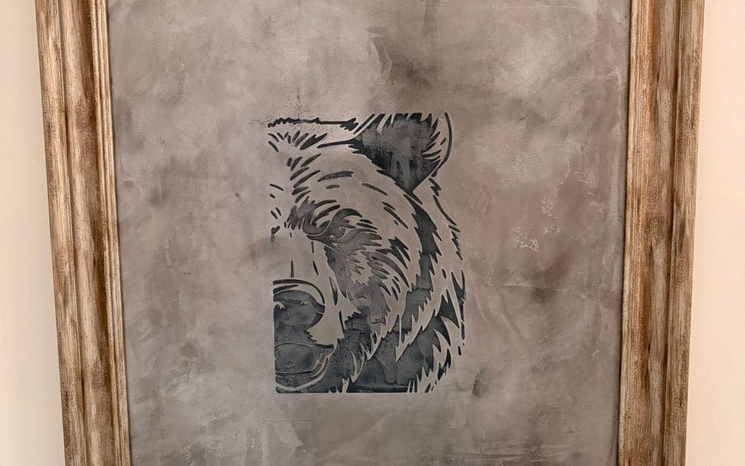 Decorative wall art featuring a bear's face in a rustic frame.
